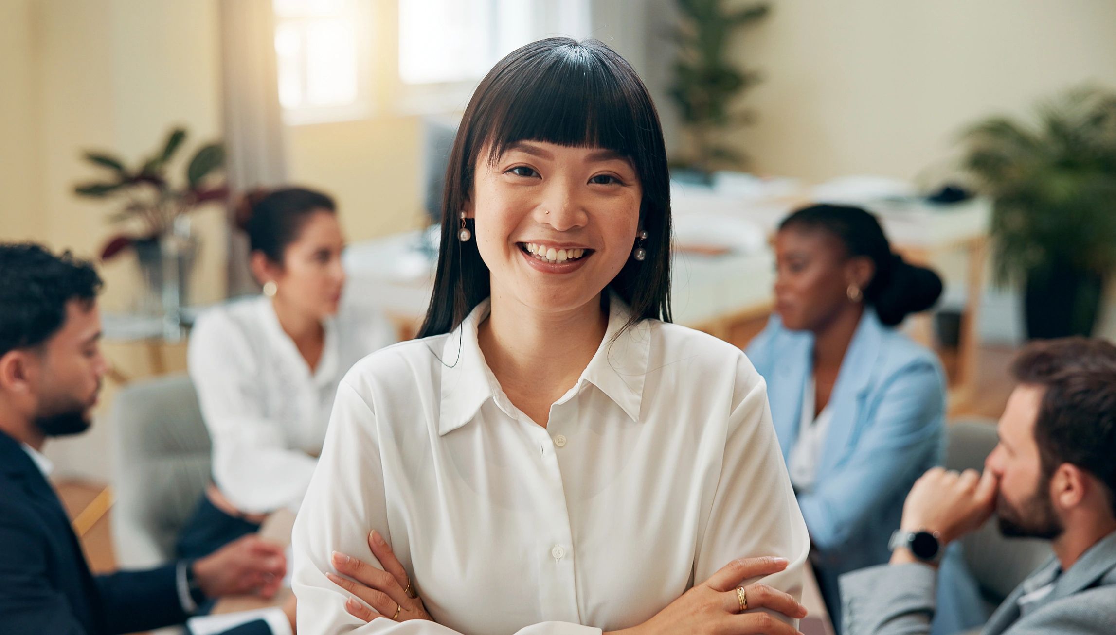 Portrait, people and woman with arms crossed, meeting and planning for entrepreneurship. Face, business coaching and manager with employees, smile and confidence for company culture or opportunity